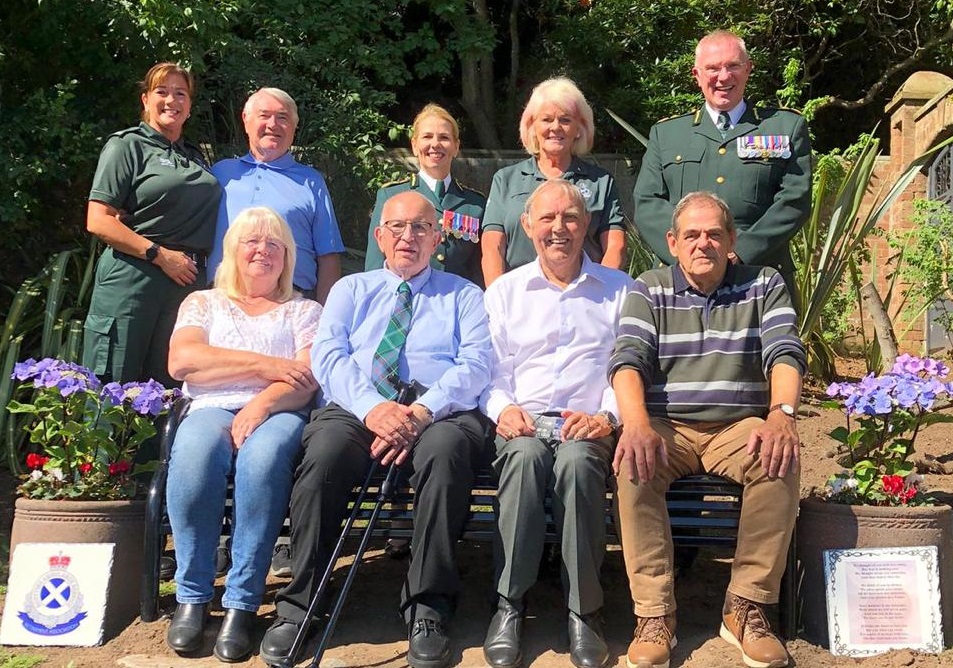 Attendees sitting on a bench in the memorial garden