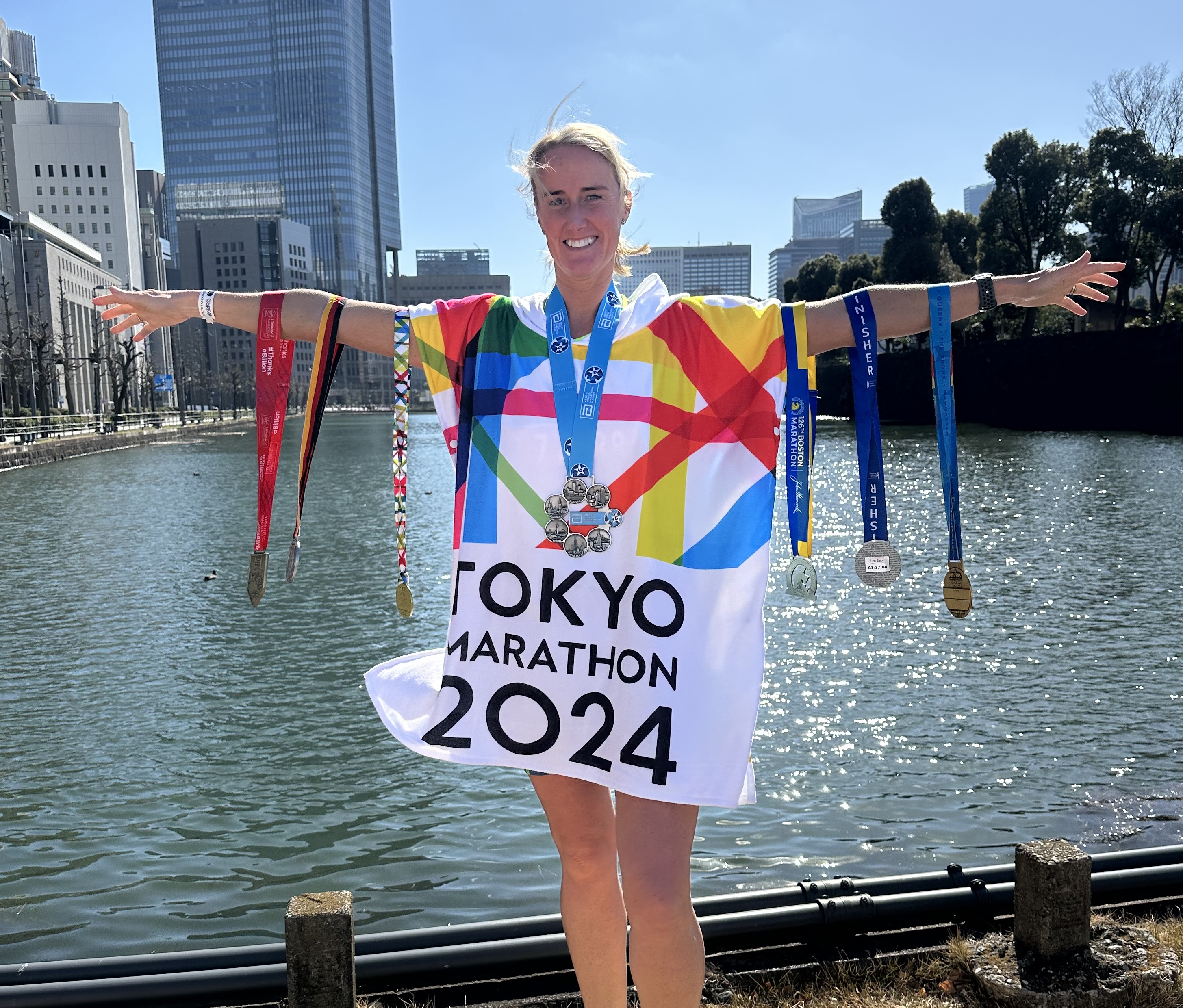 Lyn stands in front of some water showng of her medals