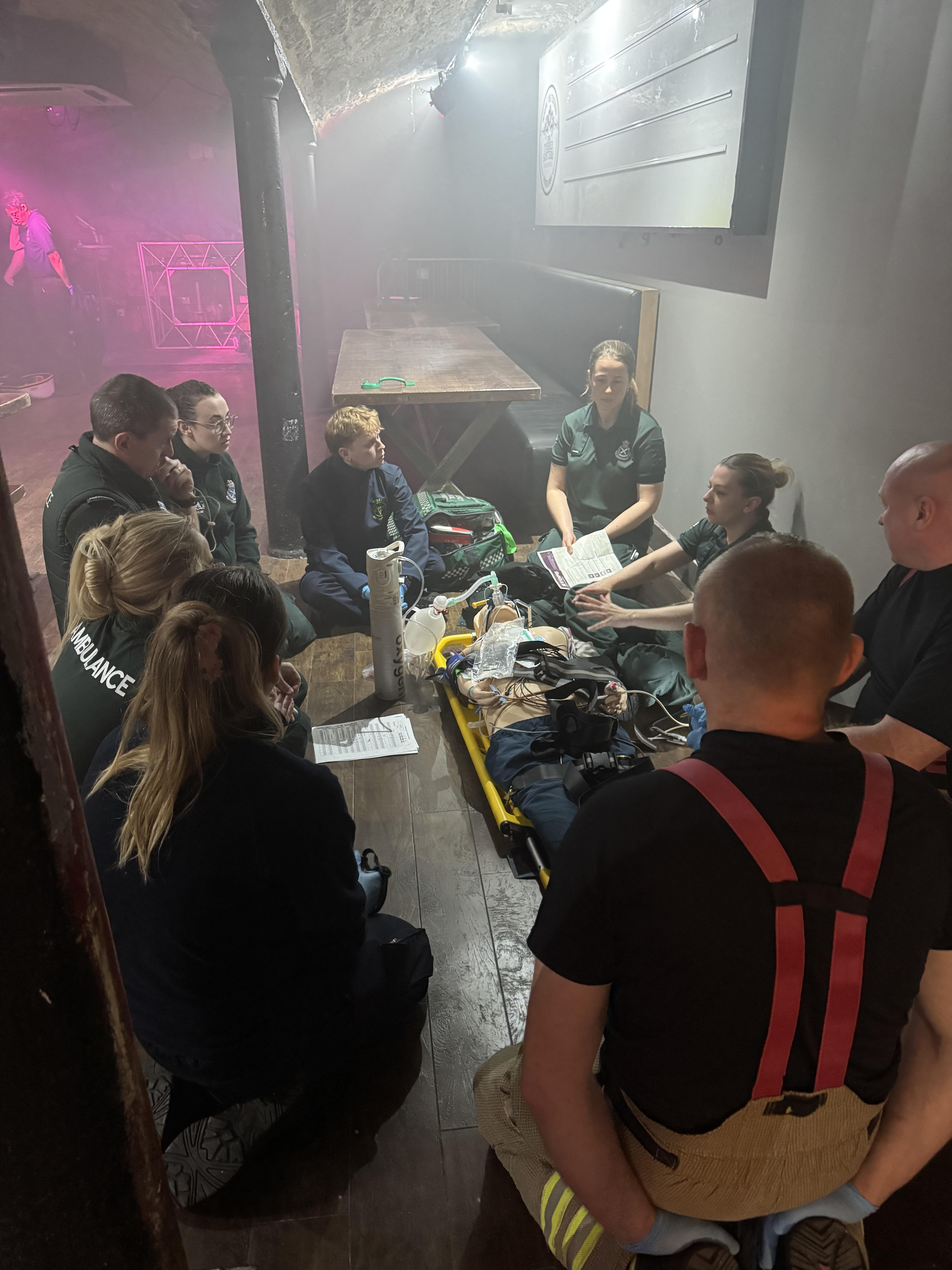 Dark lighting pic inside a nightclub with staff and volunteers getting taught how to respond to emergencies