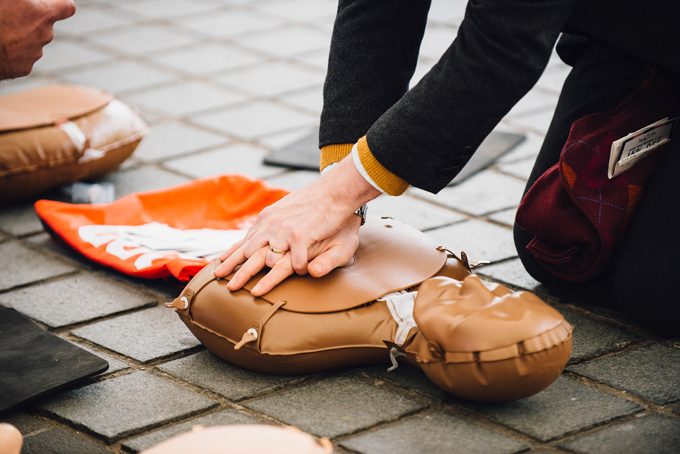 A member of the public practicing CPR on a dummy