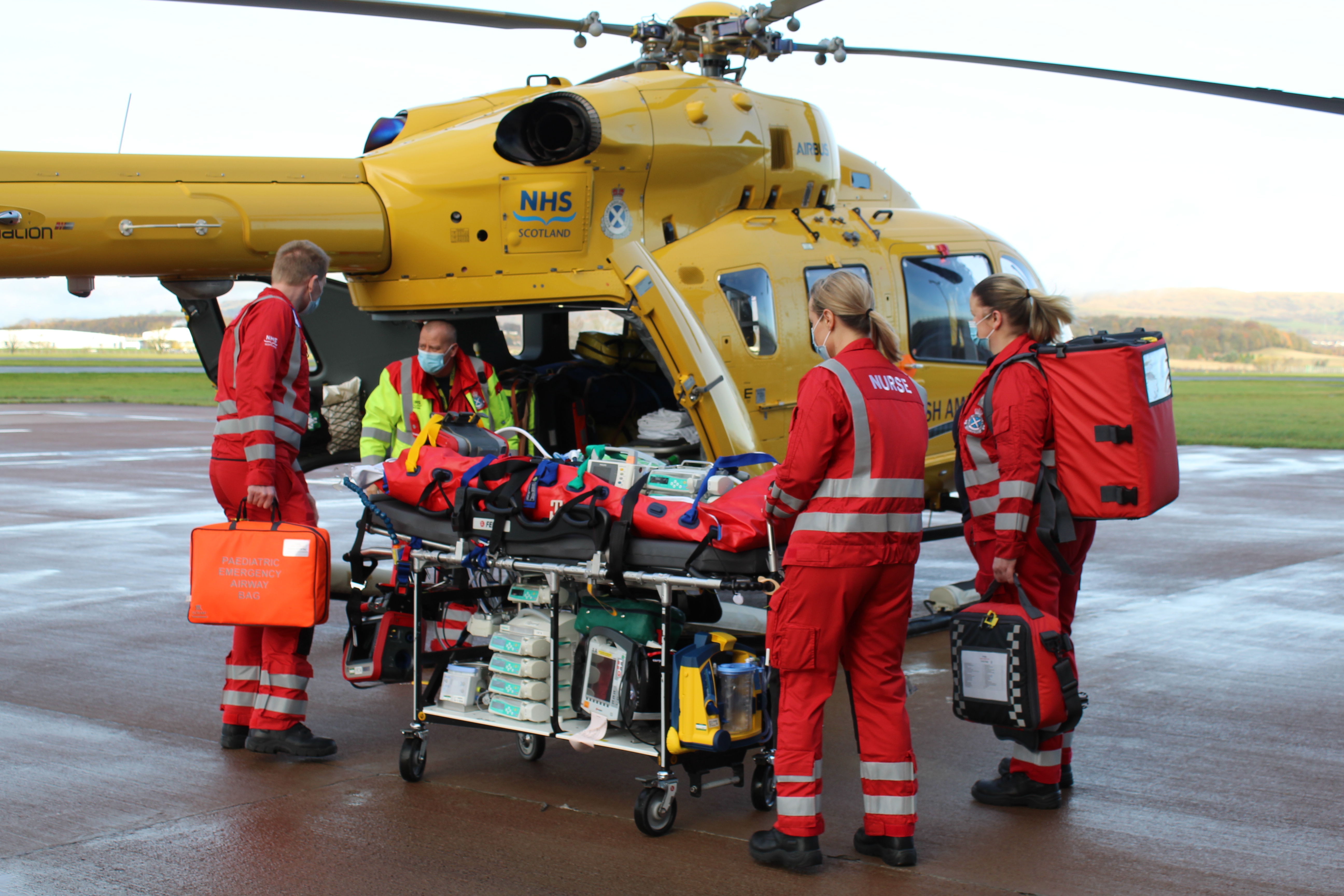 A Paediatric team transfer a child onto an air ambulance helicopter
