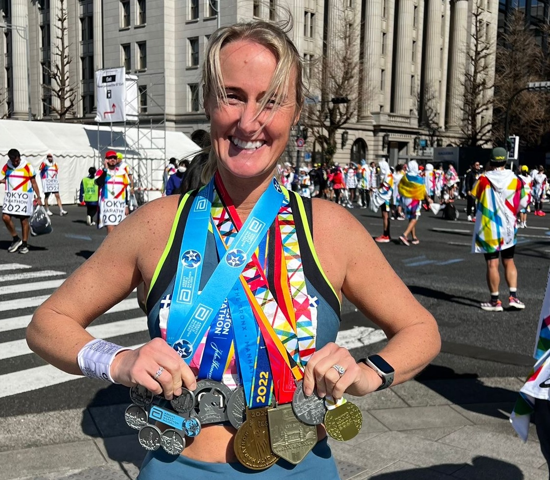 Lyn holding some of the medals she has received from marathons
