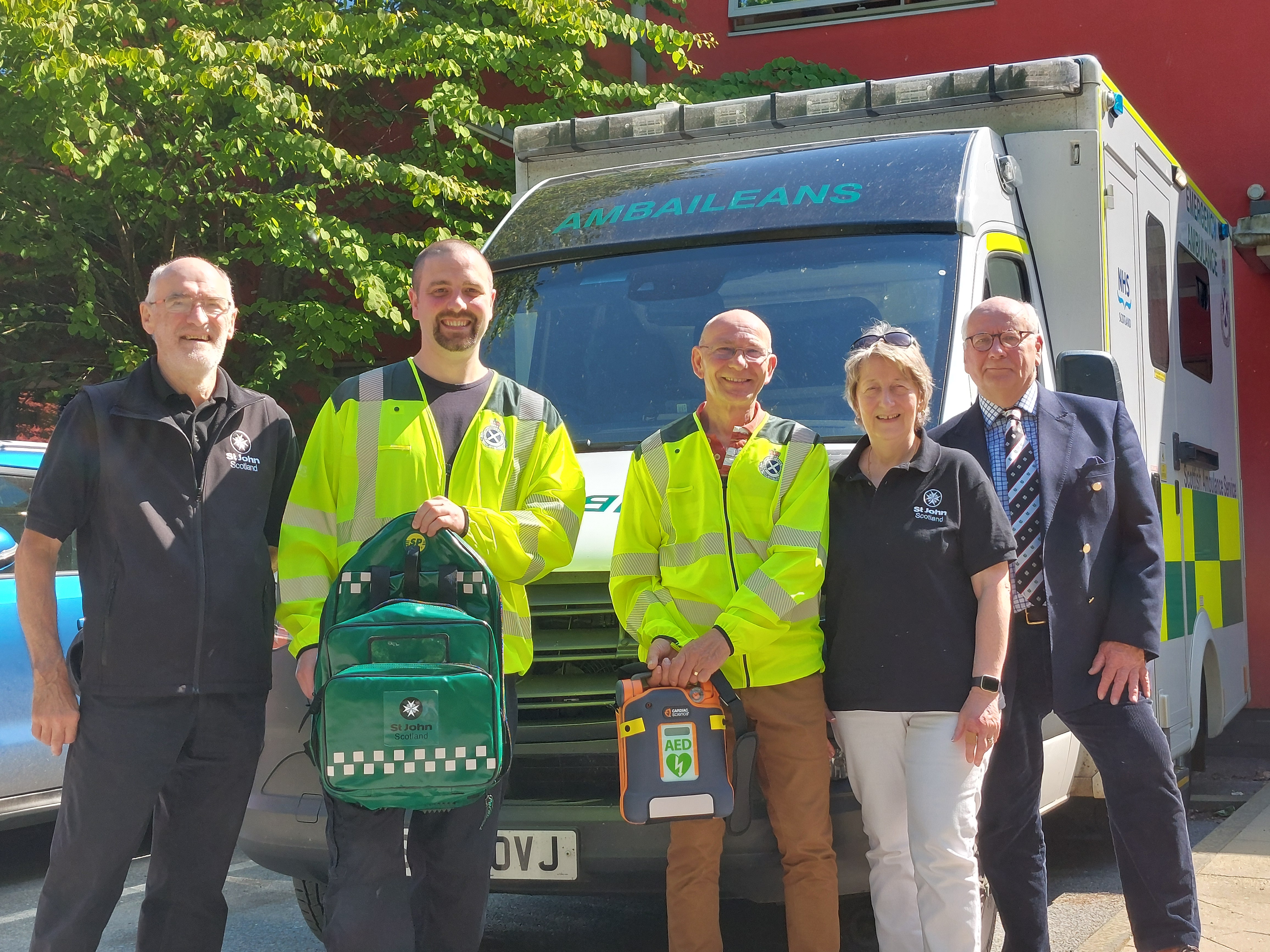 Group of Community First Responders in front of an ambulance
