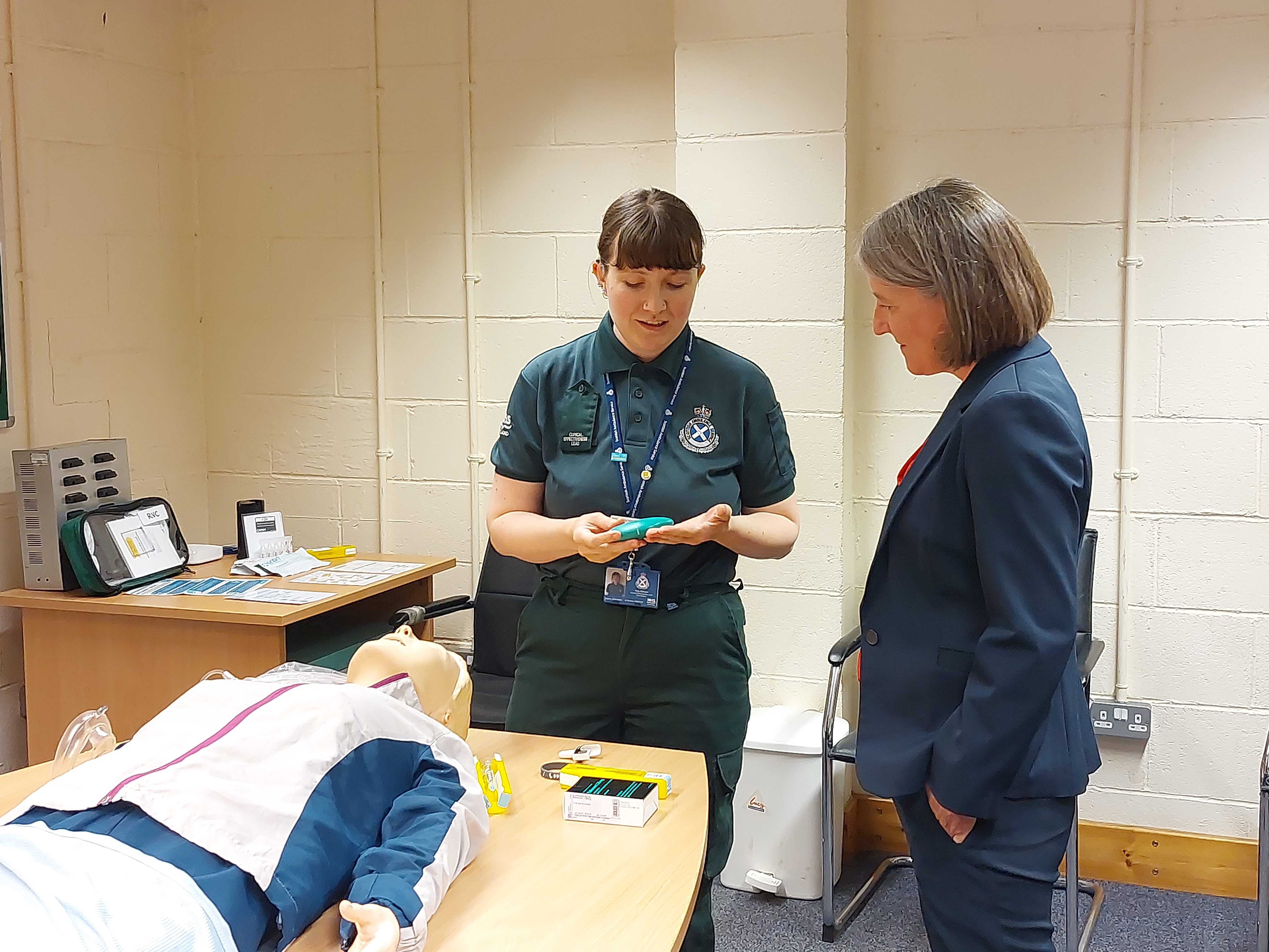 SAS staff member demonstrating a nasal naloxone kit to MSP Marie Todd.