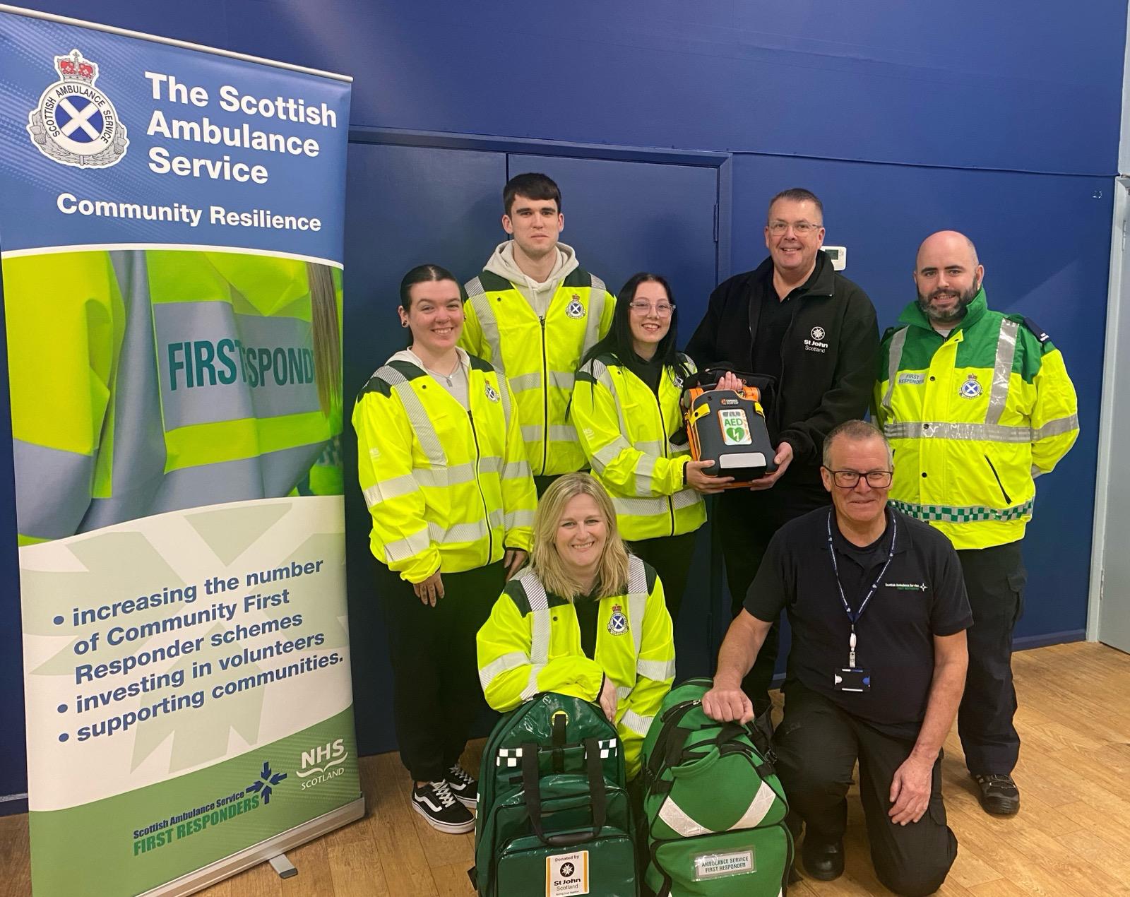 5 community first responders and 2 St John Scotland staff grouped together smiling.