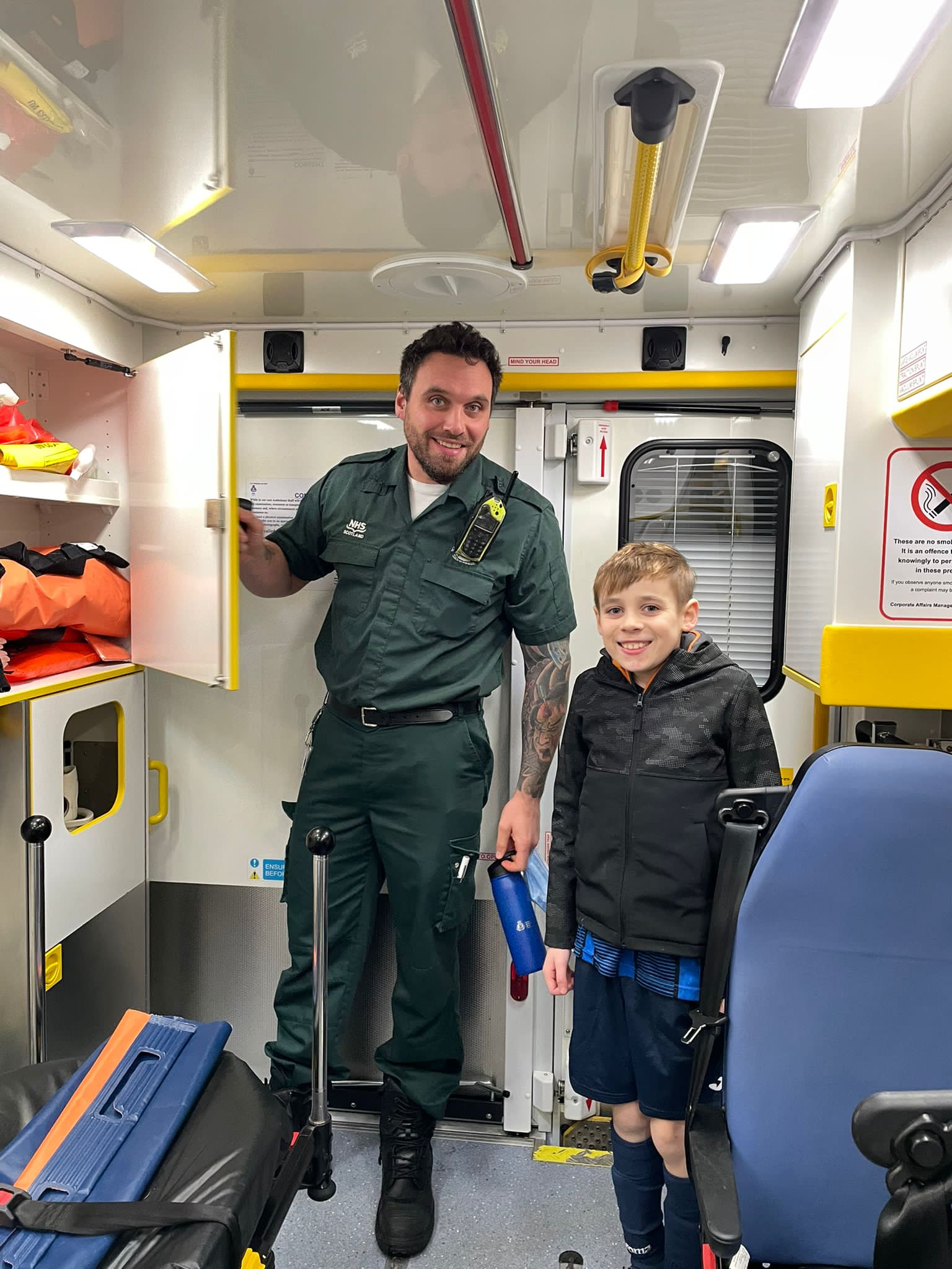 Calum with his son, in uniform in ambulance