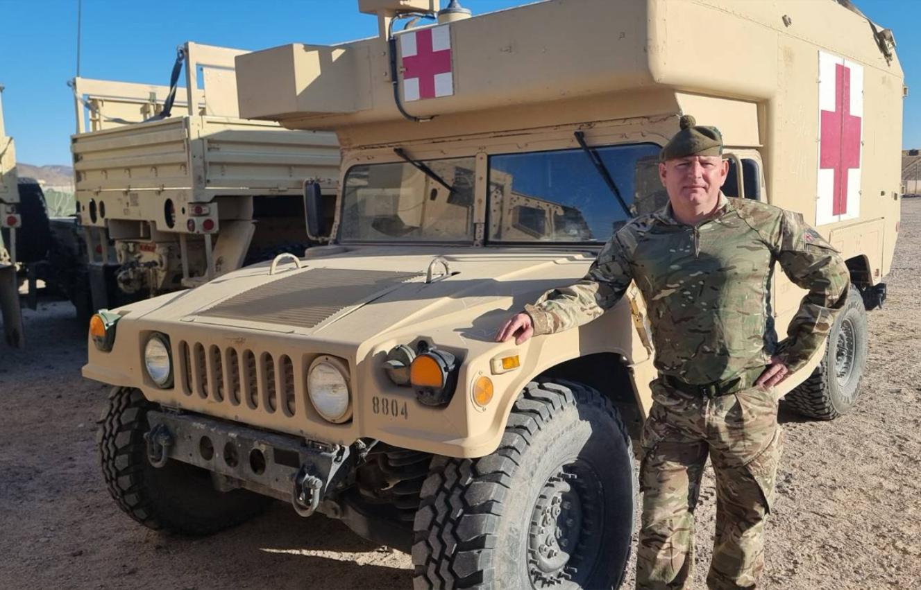Picture of John Kane in front of an army ambulance