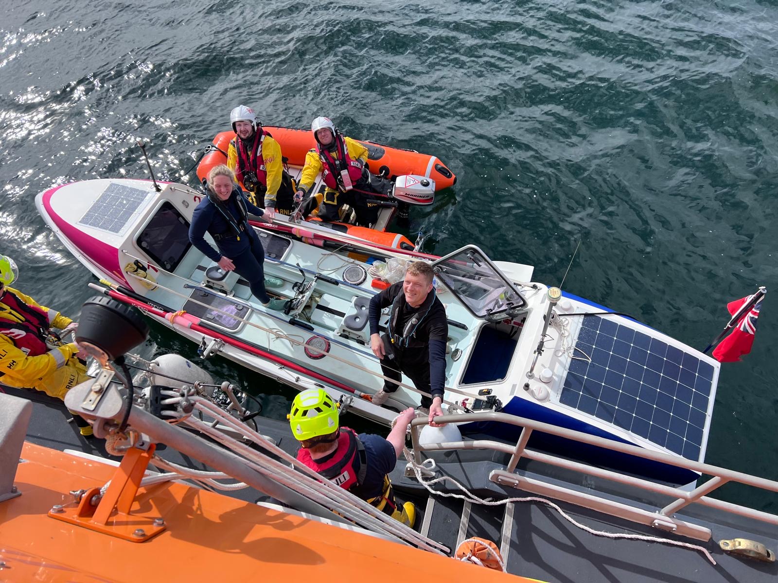 Coastguard staff look up whilst standing on a boat