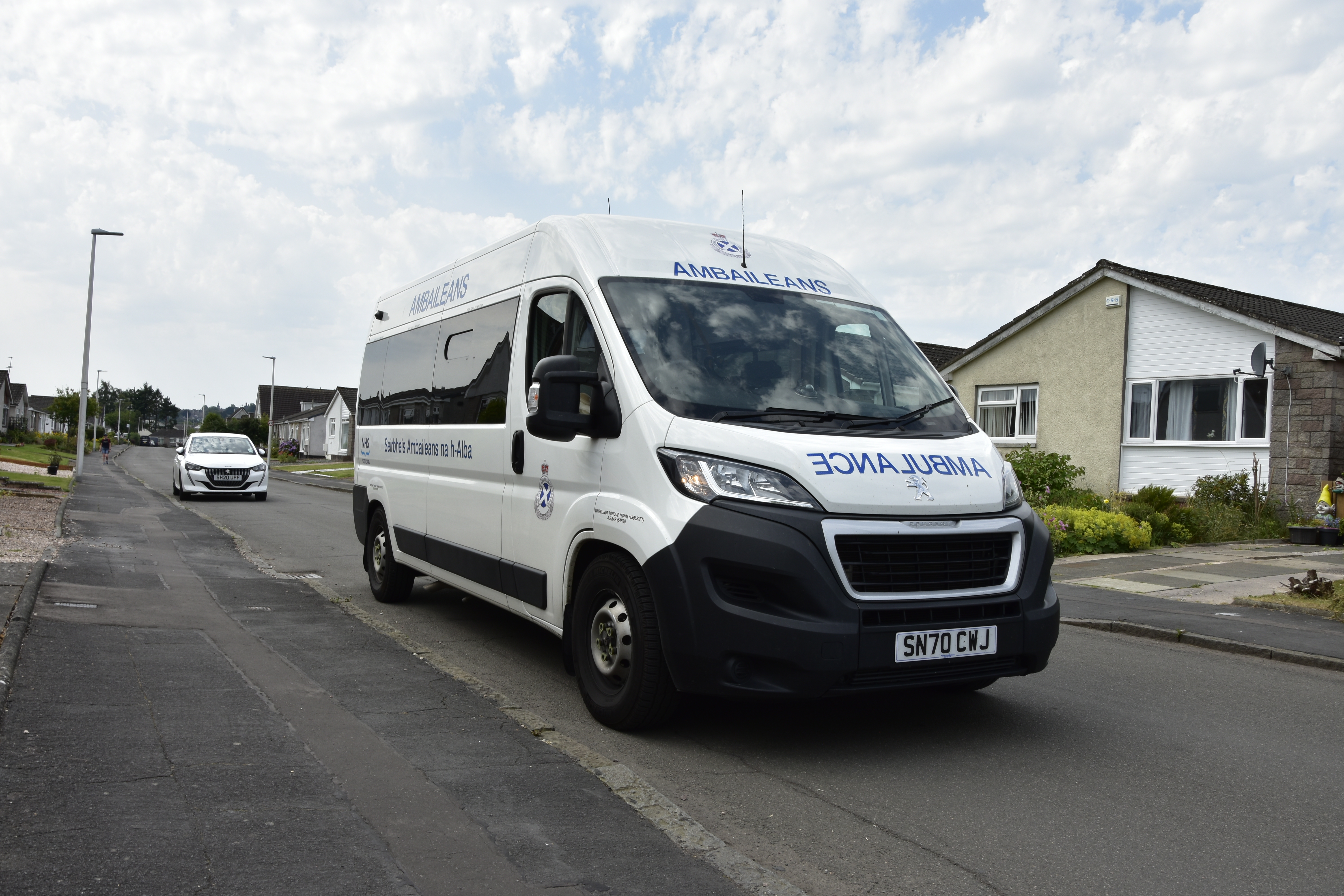 A non-emergency ambulance driving down a street