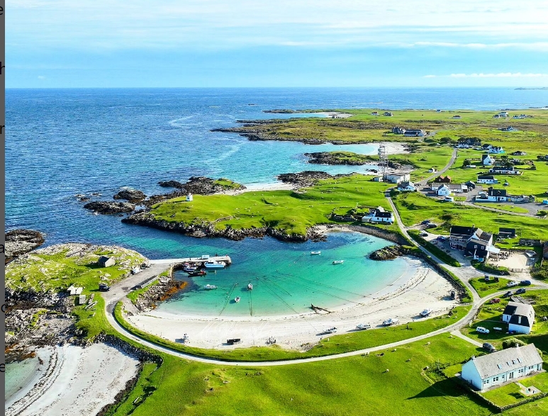 Looking down on a beach and the coast line with houses along the coast