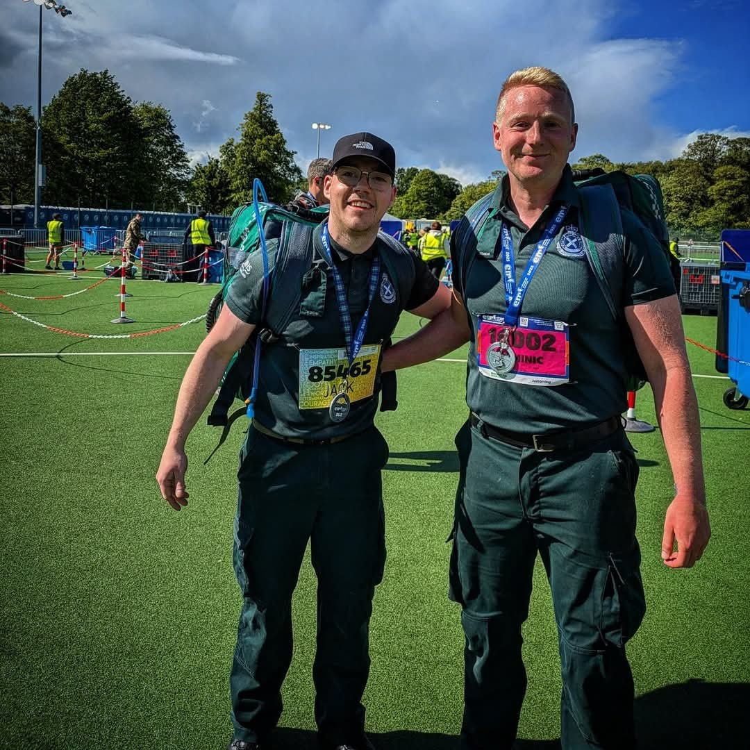 Jack and Dominic stand at the starting line with their full SAS kit and bags on them smiling