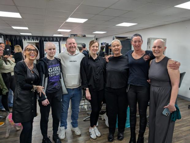 Salon staff, SAS staff and those affected by cancer stand together smiling in a group shot