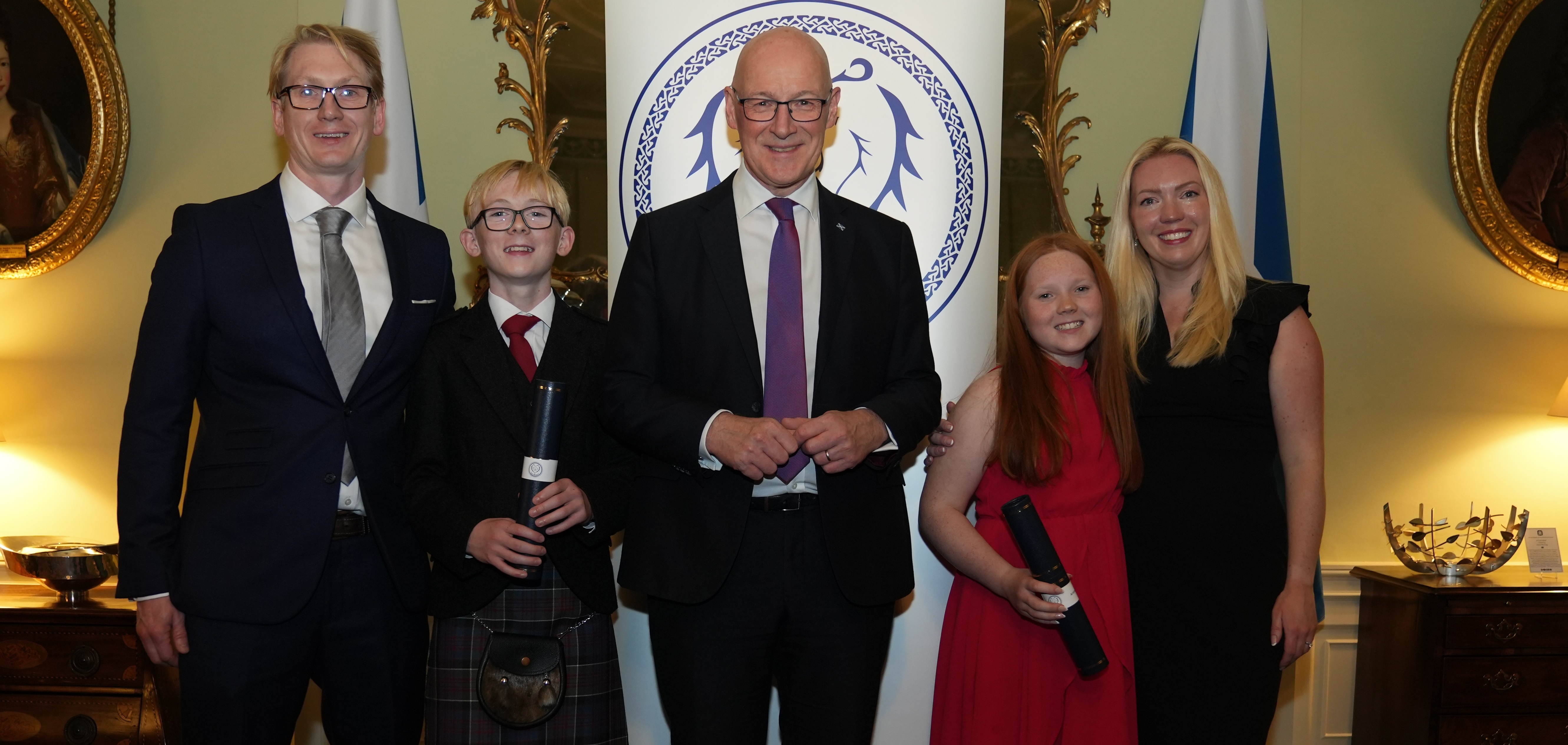 A group of 5 dressed in suits and black tie attire - John Swinney FM and the Liddle family