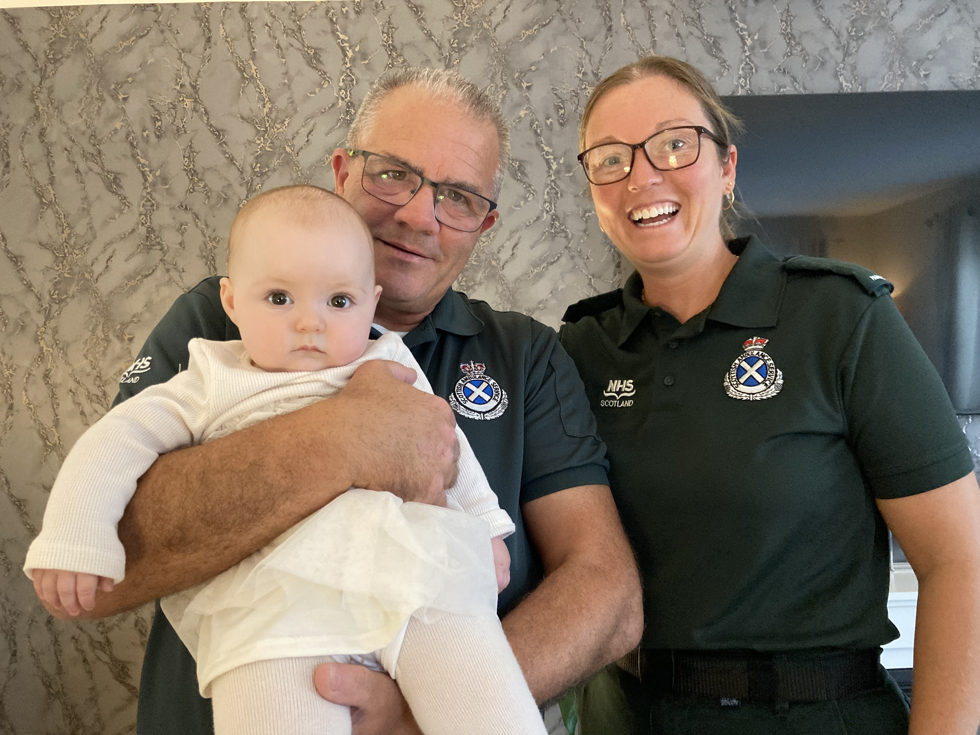 Dale and Emma delighted to be holding baby Bonnie in uniform