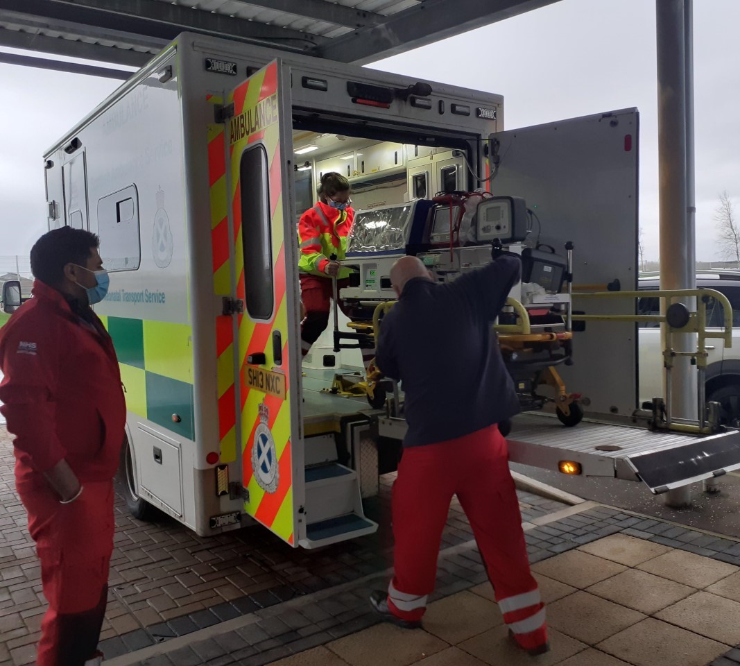 A crew put a child into a paediatric ambulance