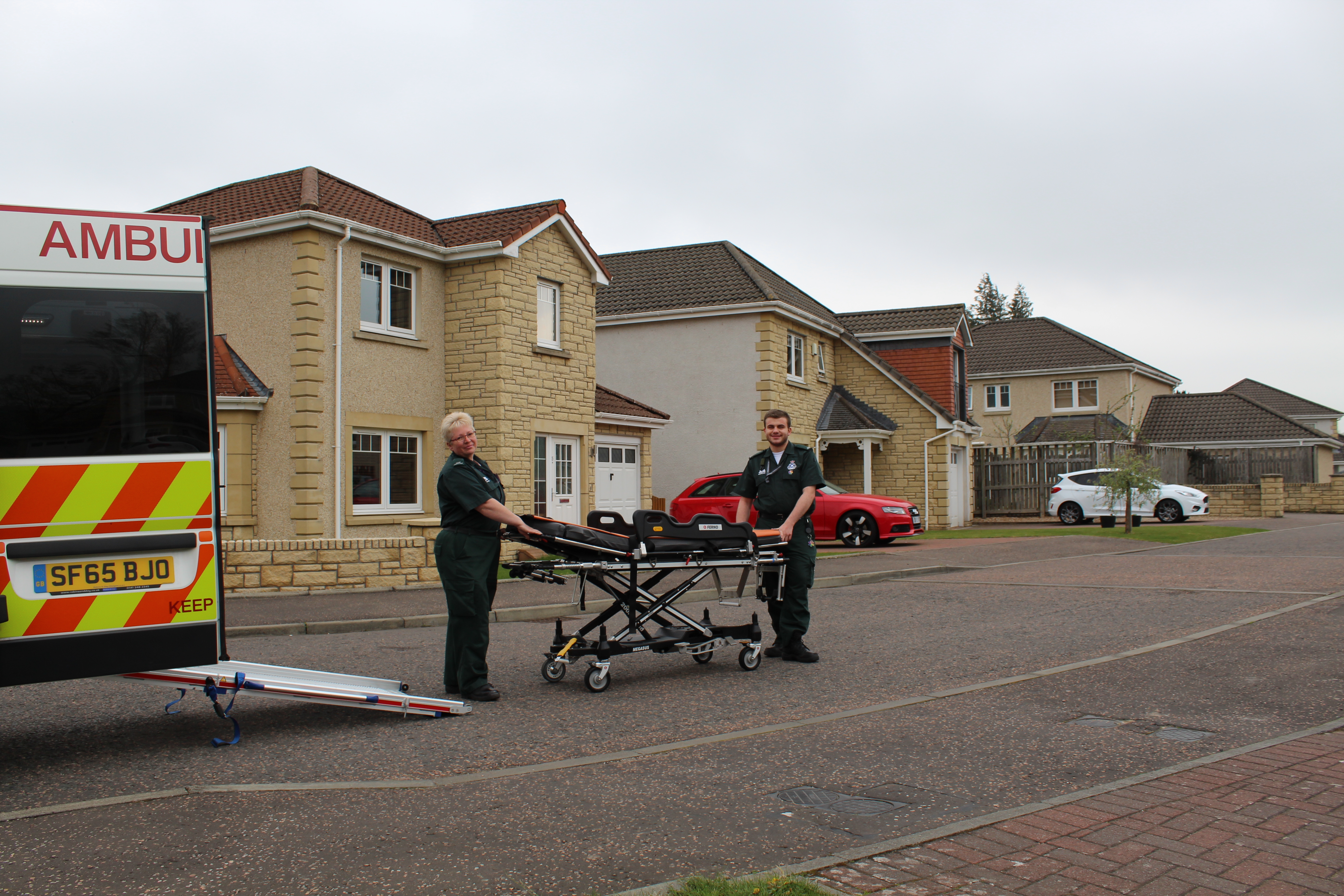 Two ambulance Care Assistance's with a stretcher