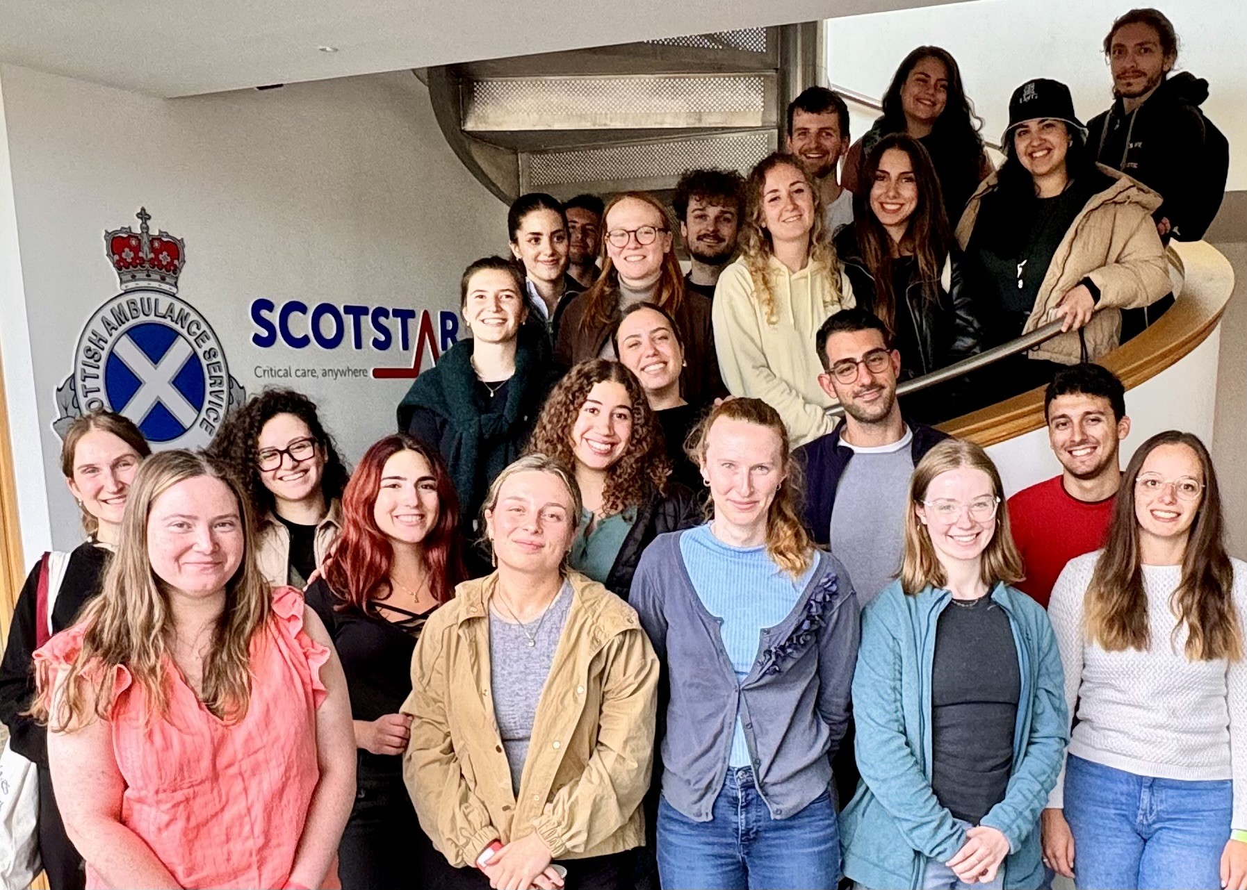Students pose on the stairs with the ScotSTAR sign behind