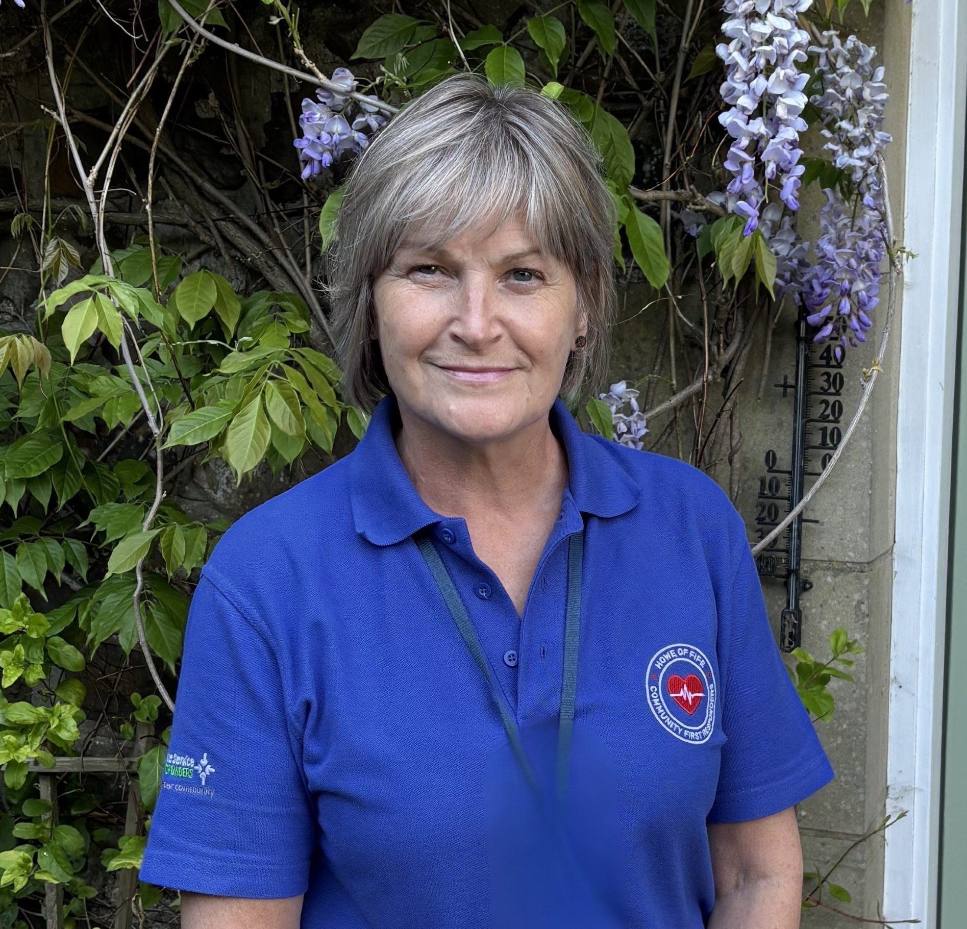 Sandra dressed in a blue CFR polo shirt smiling.