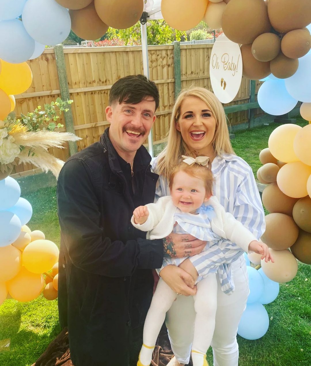 Ashleigh with her parents surrounded by balloons